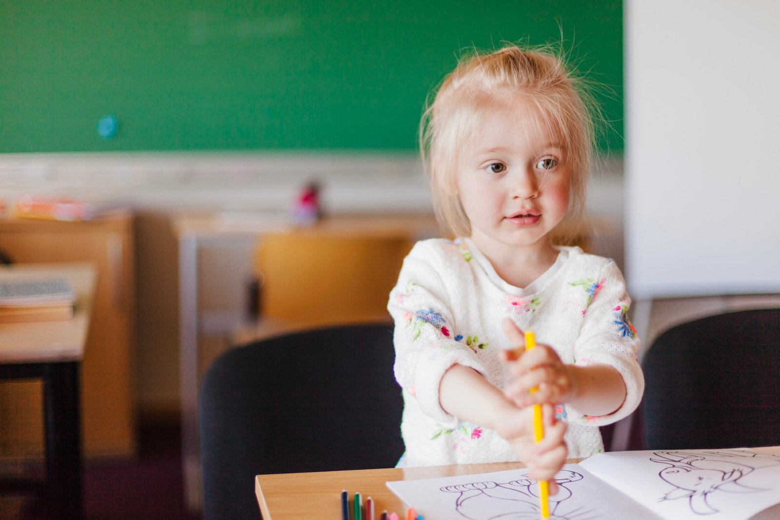 little girl sitting table classroom scaled